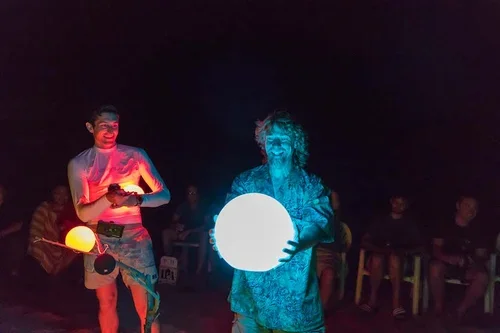 Nighttime team activity with glowing orbs on the beach