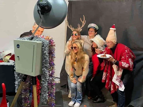 Team posing at a festive holiday photo booth with props